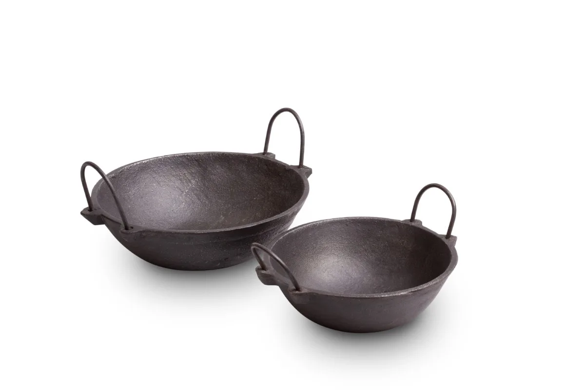 Two sizes of The Indus Valley cast iron kadai photographed together on white