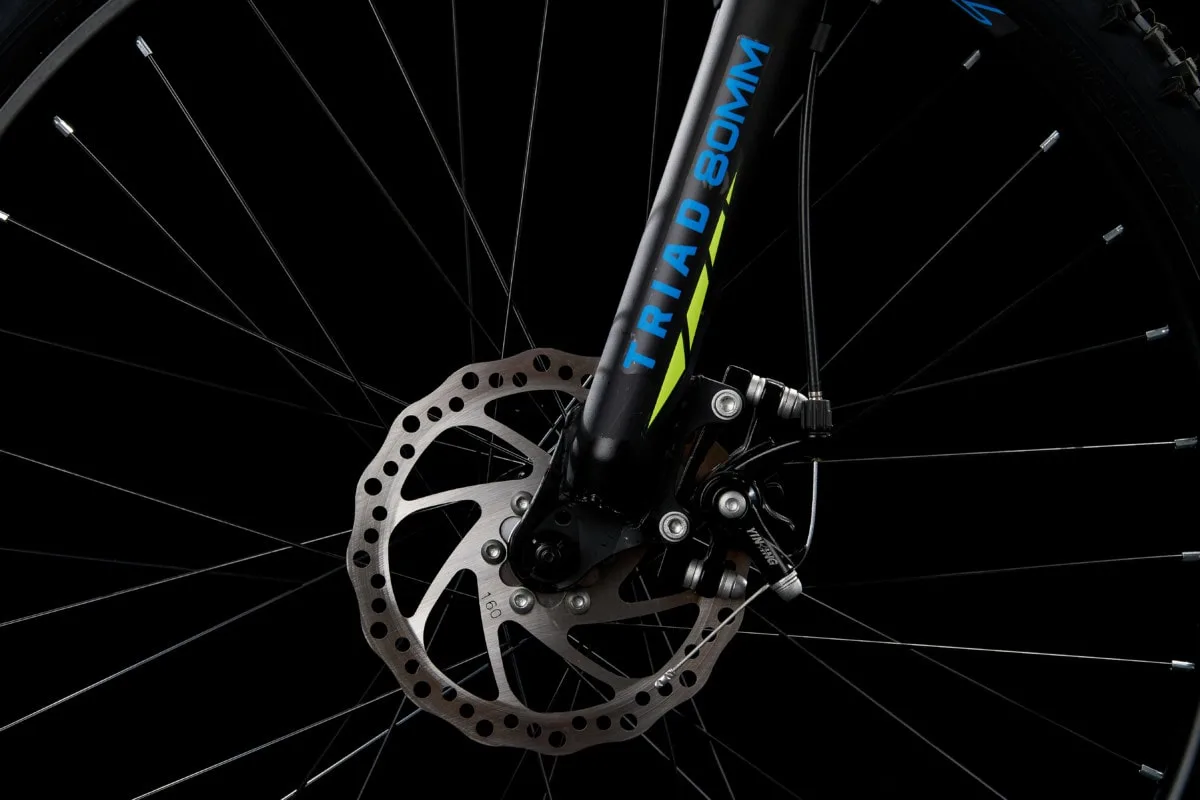 Triad M1 bicycle disc brake and fork detail, lit as a campaign hero image